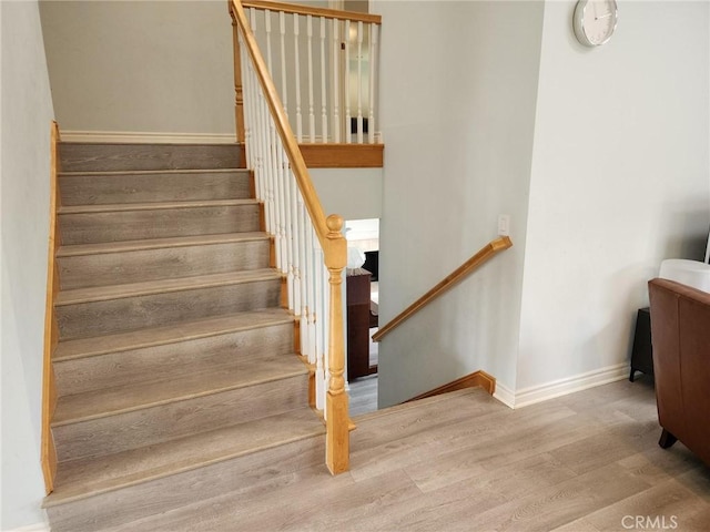 stairway with baseboards and wood finished floors