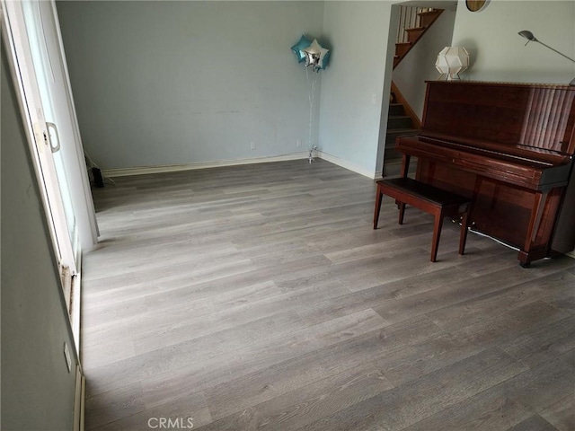 living area with stairway, baseboards, and wood finished floors