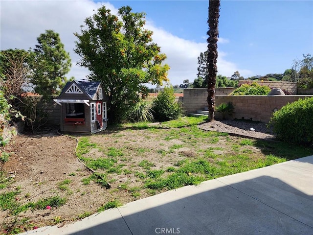 view of yard featuring a fenced backyard and an outdoor structure