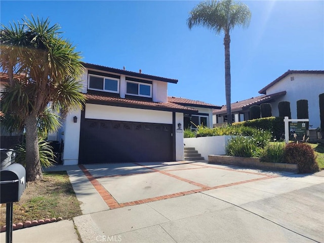 mediterranean / spanish house with a tile roof, stucco siding, and concrete driveway