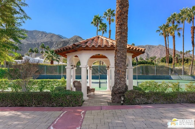 exterior space featuring a mountain view and tennis court