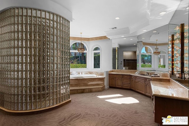 bathroom with a relaxing tiled tub, vanity, and crown molding