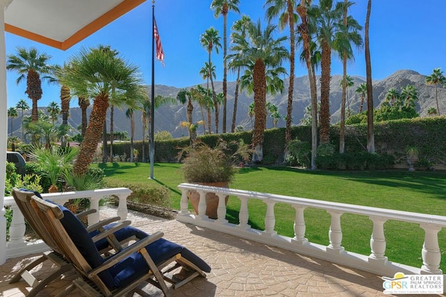 view of community featuring a mountain view, a yard, and a patio area