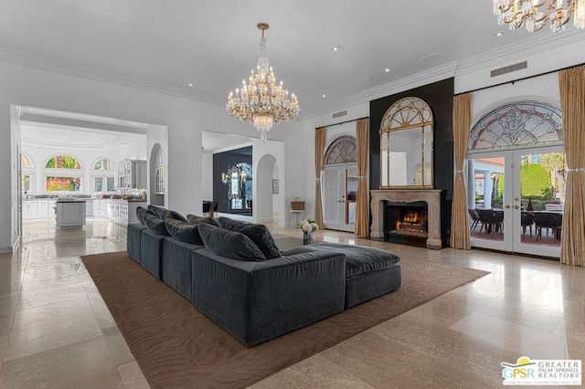 living room featuring crown molding, a notable chandelier, and french doors