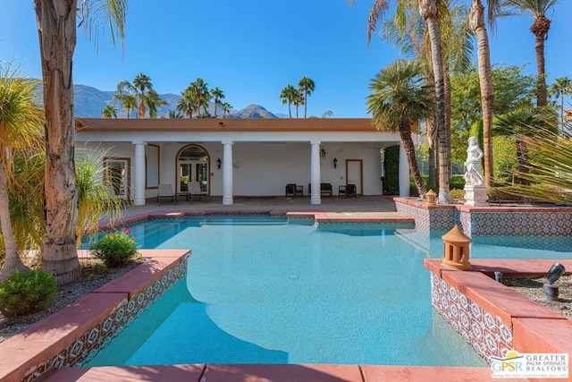 view of swimming pool featuring a mountain view, a patio area, and french doors