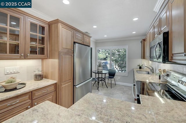 kitchen with appliances with stainless steel finishes, tasteful backsplash, sink, crown molding, and light stone countertops