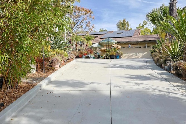 view of front facade featuring a garage and solar panels