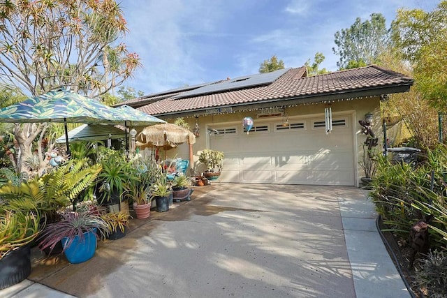 view of front facade featuring a garage and solar panels