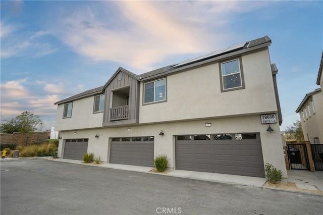 16650 Crocus Ln Unit 1, Fontana, CA 92336 - view of front of house with roof mounted solar panels, an attached garage, and stucco siding