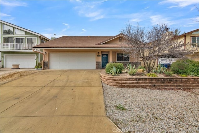 view of front of property with driveway, a tiled roof, an attached garage, and stucco siding