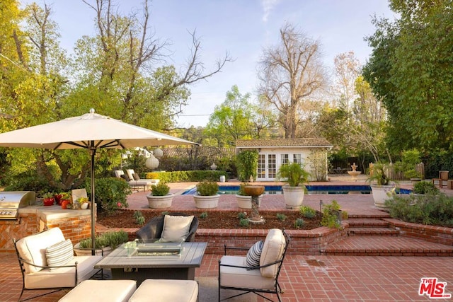 view of patio / terrace with a grill, an outdoor structure, and an outdoor fire pit