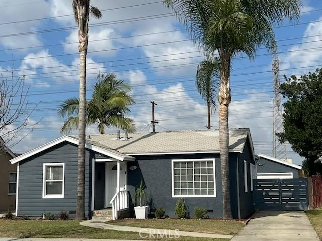 ranch-style home with a garage, a shingled roof, fence, stucco siding, and a front yard