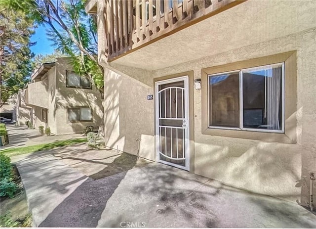 property entrance with a balcony and a patio area