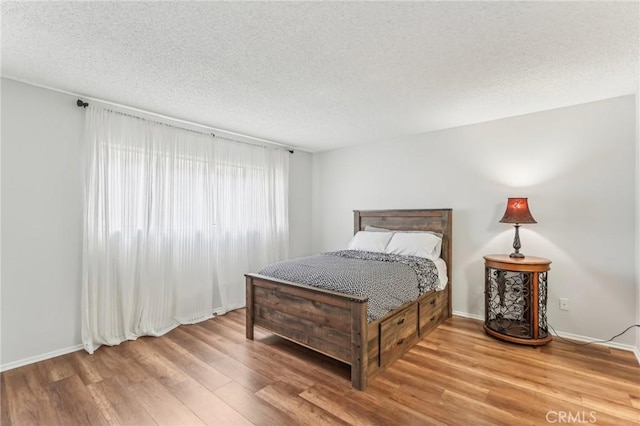 bedroom with wood-type flooring and a textured ceiling