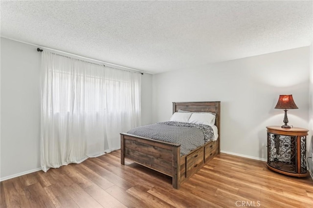 bedroom with hardwood / wood-style floors and a textured ceiling