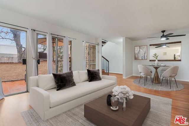 living room featuring light hardwood / wood-style flooring and ceiling fan