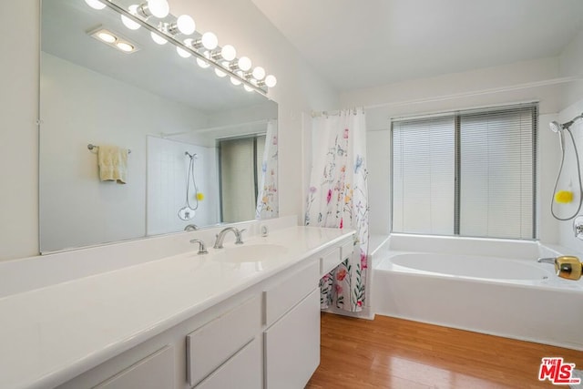 bathroom with shower / bath combination with curtain, wood-type flooring, and vanity