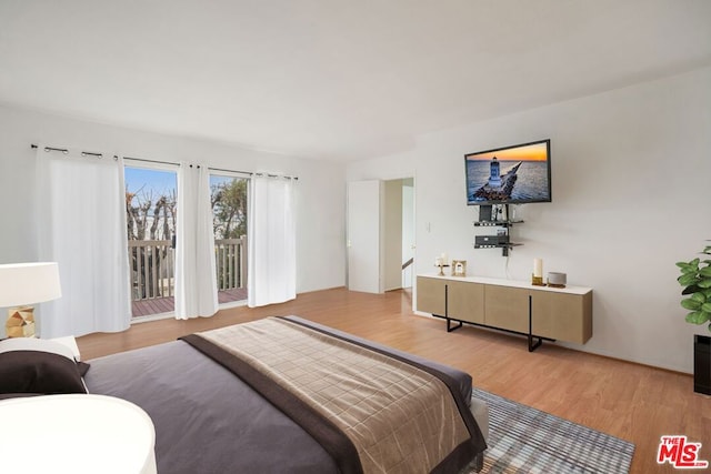 bedroom with access to exterior and light wood-type flooring