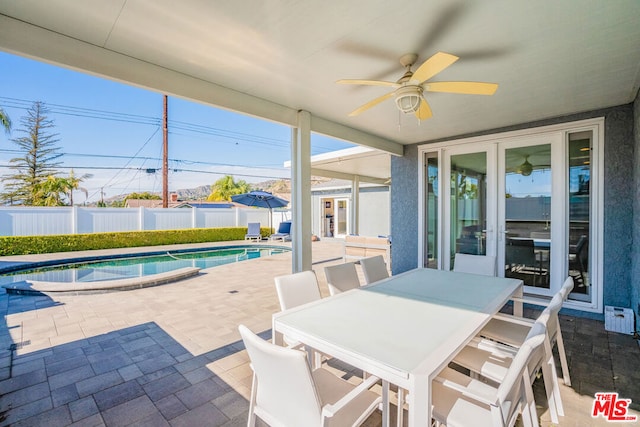 view of patio with a fenced in pool, ceiling fan, and french doors