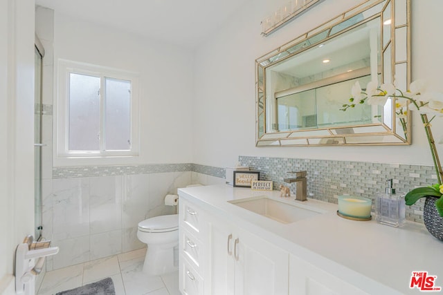 bathroom with vanity, a shower with door, and toilet