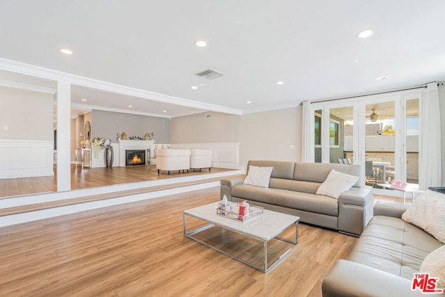 living room with crown molding and light hardwood / wood-style floors