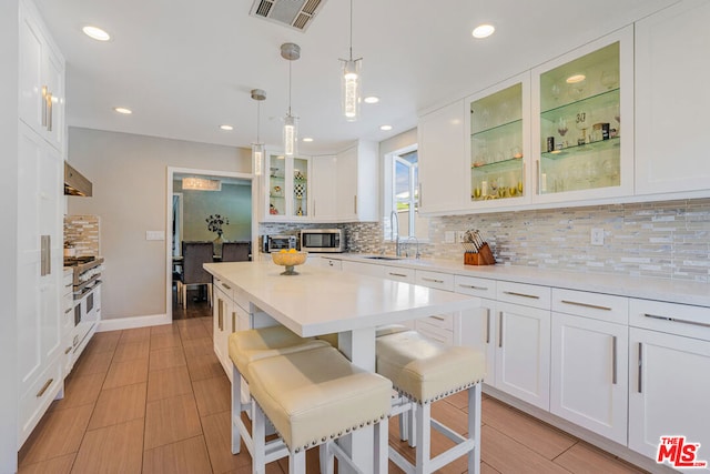 kitchen featuring white cabinetry, sink, a breakfast bar area, and appliances with stainless steel finishes