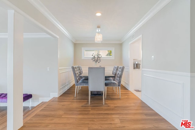 dining room featuring ornamental molding and light wood-type flooring