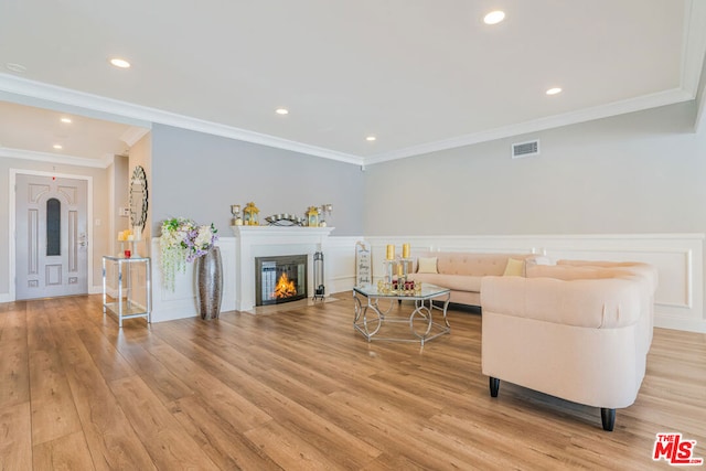 living room with ornamental molding and light hardwood / wood-style flooring