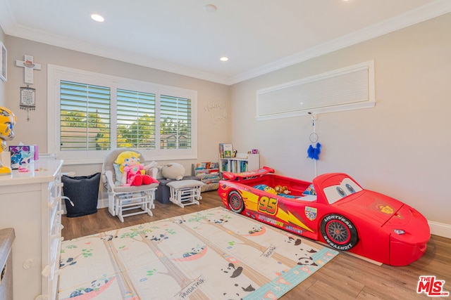 rec room with hardwood / wood-style floors and crown molding