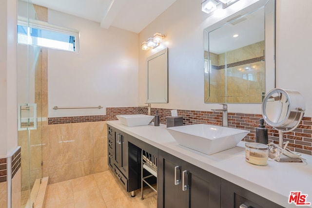 bathroom with tile patterned flooring, vanity, tiled shower, and tile walls