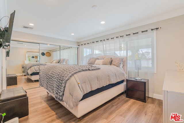 bedroom featuring crown molding and light wood-type flooring