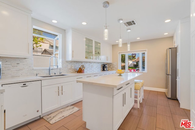 kitchen featuring sink, white cabinets, dishwasher, and a center island