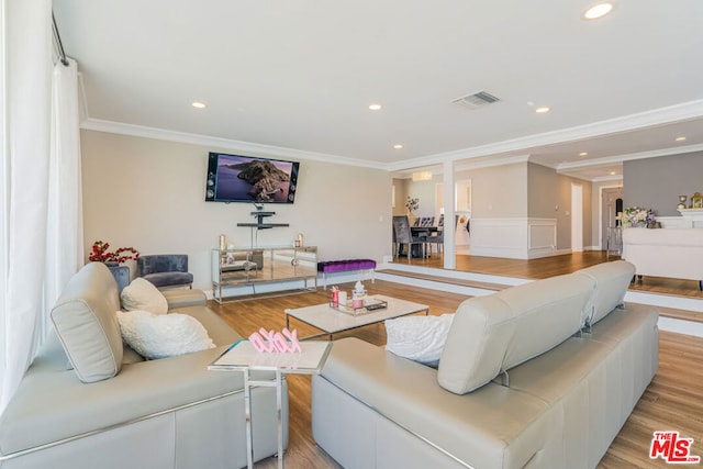 living room with light hardwood / wood-style flooring and ornamental molding