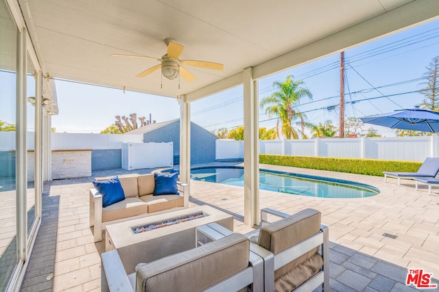 view of pool with a patio area, ceiling fan, and a fire pit