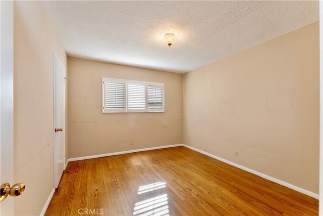 spare room with wood-type flooring and a textured ceiling