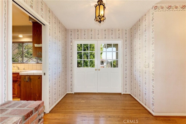 doorway to outside with french doors and light hardwood / wood-style flooring