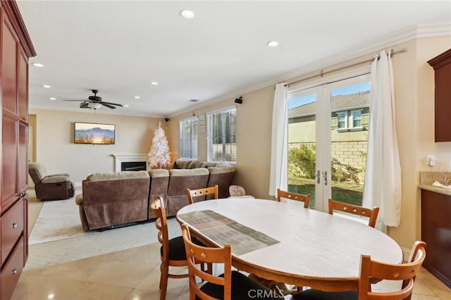 dining space with crown molding, light tile patterned floors, ceiling fan, and french doors