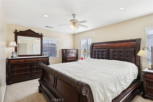 bedroom featuring multiple windows, light carpet, and ceiling fan