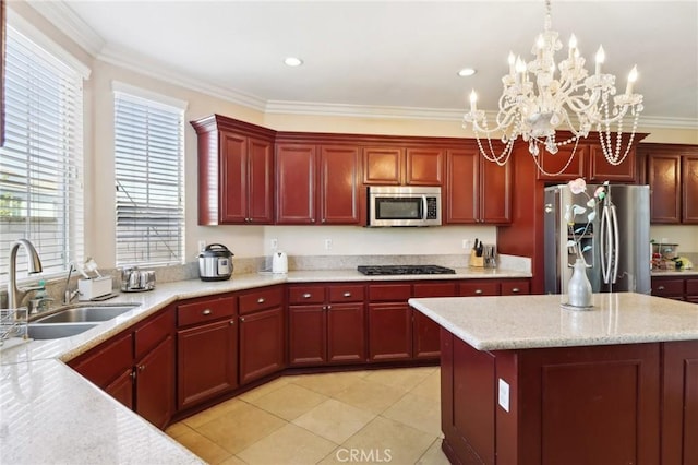 kitchen with ornamental molding, stainless steel appliances, decorative light fixtures, and sink