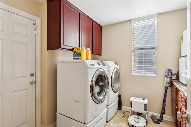 laundry room featuring cabinets, washing machine and dryer, and light tile patterned floors