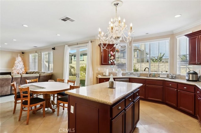 kitchen featuring sink, crown molding, a center island, decorative light fixtures, and french doors