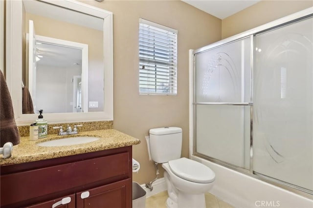 full bathroom featuring enclosed tub / shower combo, vanity, and toilet