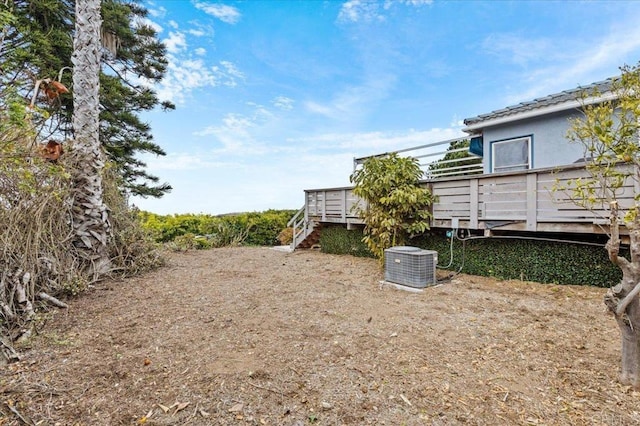 view of yard featuring central AC and a deck