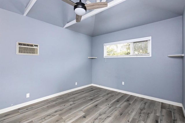 empty room with wood-type flooring, vaulted ceiling, a wall mounted AC, and ceiling fan