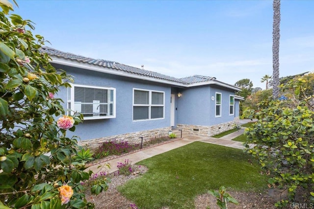 view of front facade featuring crawl space, stucco siding, a front yard, and a tile roof