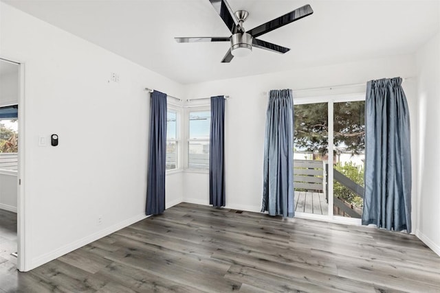 empty room with baseboards, wood finished floors, and a ceiling fan