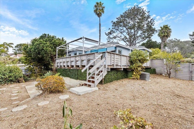 back of property featuring a wooden deck, stairway, and fence