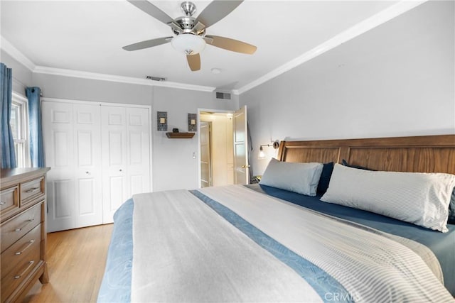 bedroom with ornamental molding, a closet, ceiling fan, and light wood-type flooring