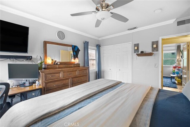 bedroom with crown molding, ceiling fan, and a closet