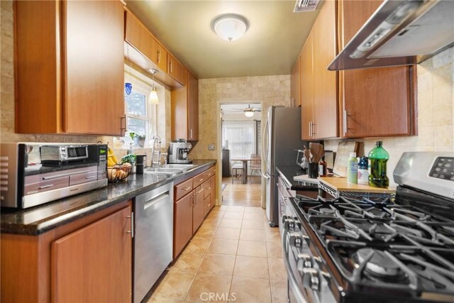 kitchen featuring sink, decorative backsplash, light tile patterned floors, ceiling fan, and stainless steel appliances